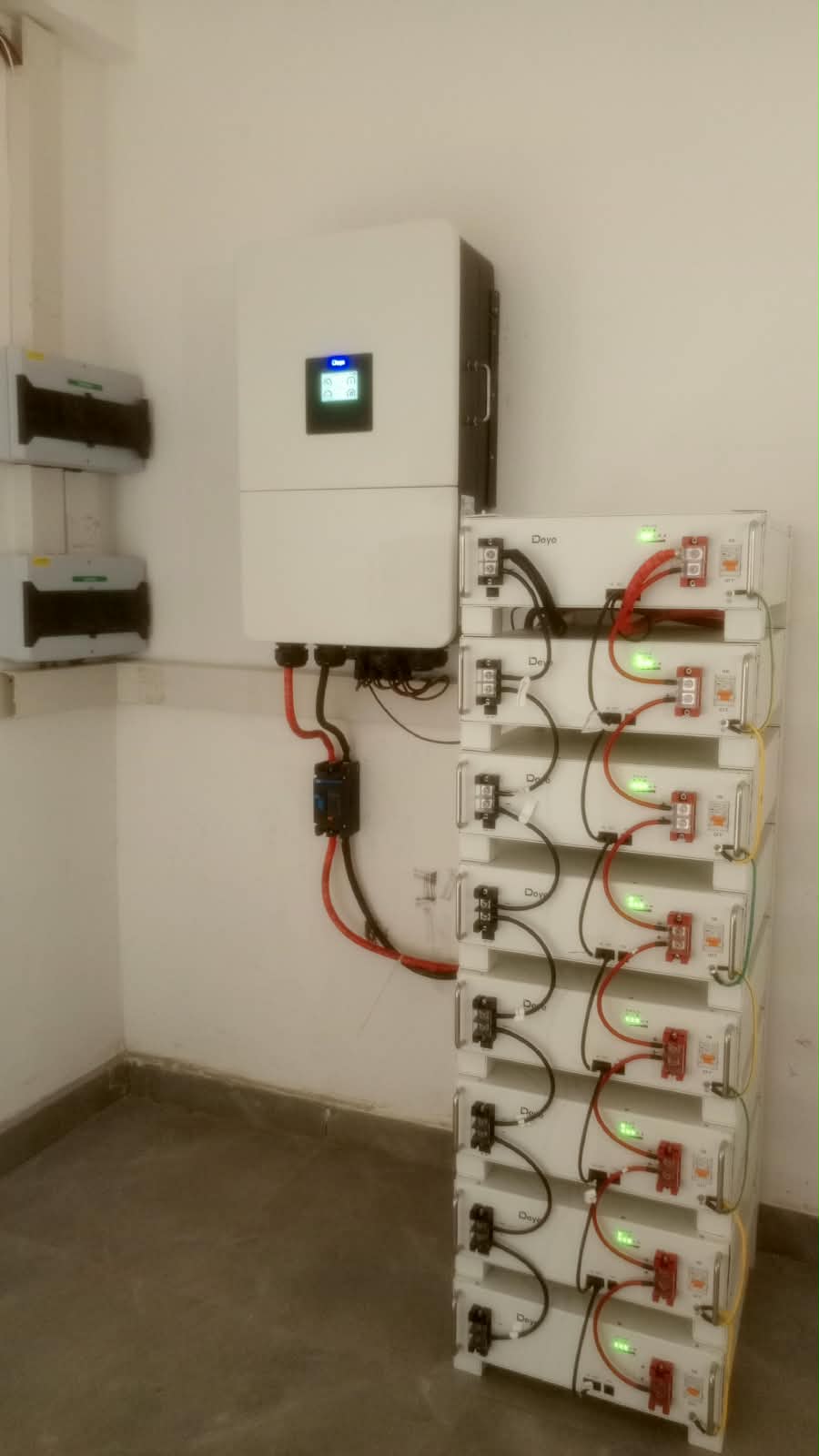 Deye hybrid inverter mounted beside an 8-module rack lithium battery stack
